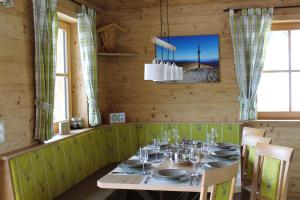 une salle à manger avec une table, des chaises et un lustre dans l'établissement Seeblickhütte Lachtal, à Niederwölz