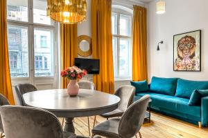 - un salon avec une table et un canapé bleu dans l'établissement Old Town Centrum Residence Apartments, à Poznań
