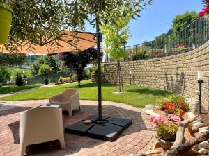 patio ze stołem, krzesłami i parasolem w obiekcie Peperosa in collina B&B w mieście Pescara