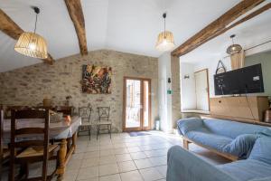 a living room with a blue couch and a table at La Mazette, les pieds dans l'eau ! Privatisée ! 16 Pers in Olargues