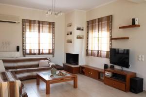 a living room with a couch and a tv at Lovos House in Laganas