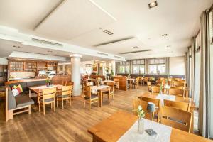 a restaurant with wooden tables and wooden chairs at Langwieder See in Munich