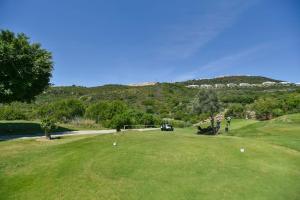 un campo de golf con un carrito de golf en un green en Espectacular Apartamento Rodeado de Campos de Golf, en Casares