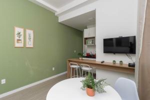 a living room with green walls and a counter with a television at 360 Higienópolis in São Paulo