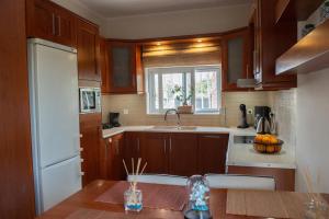 a kitchen with wooden cabinets and a sink and a window at Lovos House in Laganas