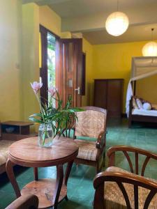 ein Zimmer mit einem Tisch mit einer Blumenvase darauf in der Unterkunft Villa Sambal in Yogyakarta