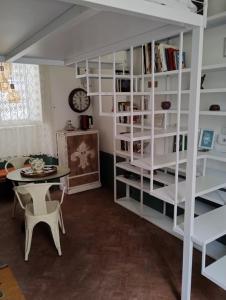 a room with white book shelves and a table at Il piccolo rifugio in Caserta