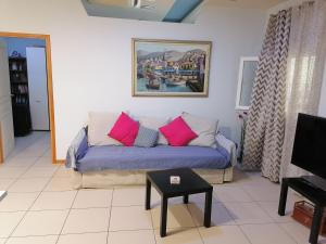 - un salon avec un canapé bleu et des oreillers roses dans l'établissement Hermes Gerakas-Athens, à Athènes