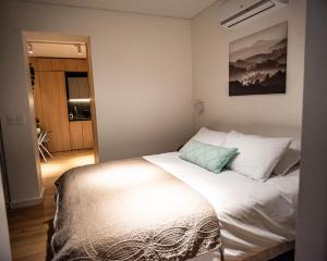 1 dormitorio con cama blanca y almohada azul en Loft Nuevo en Santiago, Barrio Lastarria, en Santiago