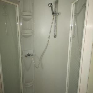 a shower in a bathroom next to a glass door at Camping Park Soline - Rose PB -Mobile Home in Biograd na Moru