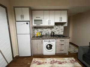 eine Küche mit einem weißen Kühlschrank und einer Waschmaschine in der Unterkunft Giriş kat,Merkezi konum, Alışveriş merkezi karşısı'3' in Antalya
