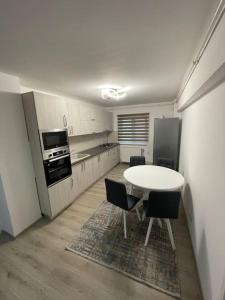 a kitchen with a table and chairs in a room at Apartament regim hotelier in Caransebeş