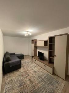 a living room with a couch and a tv at Apartament regim hotelier in Caransebeş