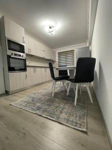 a kitchen with a dining table and two chairs at Apartament regim hotelier in Caransebeş