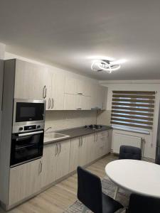 a kitchen with a table and a stove top oven at Apartament regim hotelier in Caransebeş