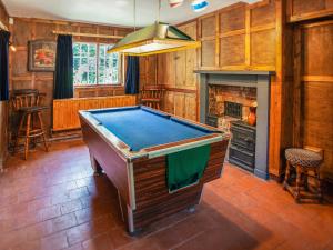 a pool table in a room with a fireplace at The Cottage in Stockton on Teme