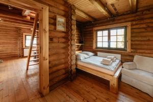 a bedroom in a log cabin with a bed and a ladder at Bieszczadzka Bania in Lesko