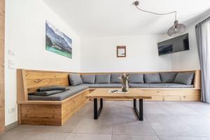 een woonkamer met een bank en een tafel bij Alpenrose Ferienwohnungen in Lenggries