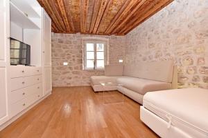 a living room with a couch and a tv at Pearl in the Heart of Old Town on Belavista Square in Herceg Novi in Herceg-Novi