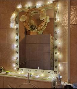 a bathroom with a mirror and a sink with lights at Parányi Porta Bakonybél in Bakonybél