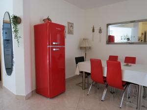 a red refrigerator in a room with a table and chairs at Eco friendly apartment in Ližnjan