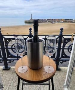 a bottle of wine in a bucket on a table with two glasses at Imperial Suites Heart Of Margate! sleeps 6 in Kent