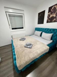 a bedroom with a blue bed with two towels on it at La Apartamento in Jagodina