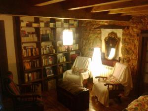 AleaにあるCasa Rural La Posada del Albaの椅子2脚と本棚のあるリビングルーム