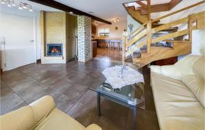 a living room with a couch and a fireplace at Awesome Home In Lidzbark Warminski With House A Panoramic View in Lidzbark Warmiński