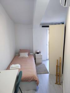 a small bedroom with a bed and a mirror at Vista Panorâmica Amadora in Amadora