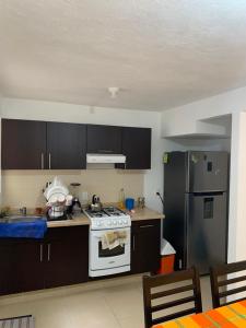 a kitchen with a white stove and a refrigerator at Casa Meneses in Sanctórum