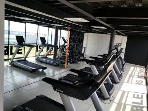 een fitnessruimte met rijen loopbanden en crosstrainers bij Departamento familiar o de negocios in Guadalajara