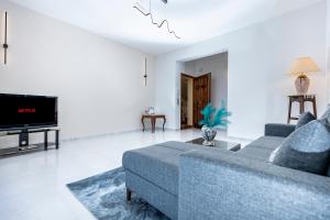 un soggiorno con un divano blu e una TV di Casa vacanza lido a Sciacca