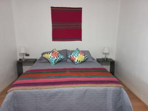 a bedroom with a bed with two pillows on it at Casa Sutar Las Higueras in San Pedro de Atacama