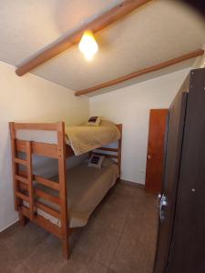 a small room with two bunk beds and a refrigerator at Casa Sutar Las Higueras in San Pedro de Atacama