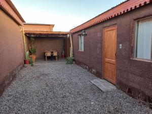 Une allée avec une table et un bâtiment avec une porte dans l'établissement Casa Sutar Las Higueras, à San Pedro de Atacama