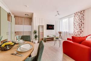 ein Wohnzimmer mit einem Tisch und einem roten Sofa in der Unterkunft Dodi RED Apartament in Arad