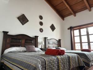 1 dormitorio con 2 camas y ventana en Casa Los Habitantes Antigua Guatemala, en Antigua Guatemala