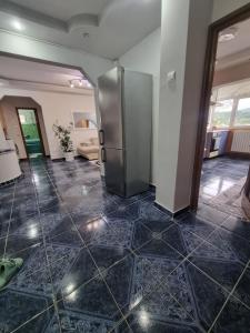 a stainless steel refrigerator in a room with a tile floor at Emily Residence in Curtea de Argeş