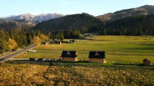 une vue aérienne sur un champ avec des maisons et une route dans l'établissement Chałupy Góralskie, à Witów