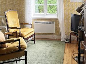een woonkamer met stoelen, een televisie en een raam bij Holiday home Tystberga III in Tystberga