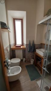 a bathroom with a sink and a toilet and a window at Antica Dimora affittacamere in Cantù