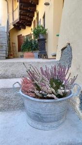 un cubo con flores al lado de un edificio en Antica Dimora affittacamere en Cantù