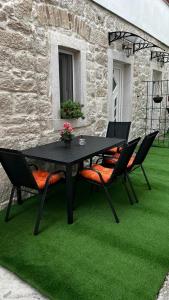 czarny stół i krzesła na zielonym trawniku w obiekcie Grošovi Dvori w mieście Opuzen