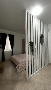 a bedroom with a bed with two potted plants at Grošovi Dvori in Opuzen