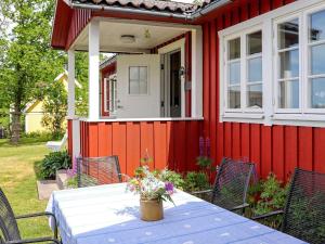 une table avec des fleurs devant une maison dans l'établissement 6 person holiday home in Sl inge, à Slöinge