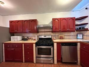 uma cozinha com armários vermelhos e um forno com placa de fogão em Casa Los Habitantes Antigua Guatemala em Antigua Guatemala