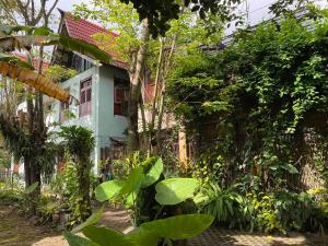 une maison blanche avec des plantes devant elle dans l'établissement Villa Sambal, à Yogyakarta