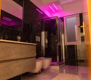 e bagno con servizi igienici e doccia con luci viola. di Casa vacanza lido a Sciacca Altre 31 foto