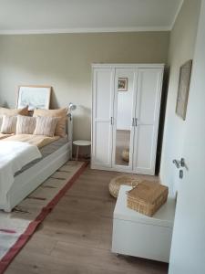 ein Schlafzimmer mit einem Bett und einem weißen Schrank in der Unterkunft Lausitzer Auszeit in Laubusch